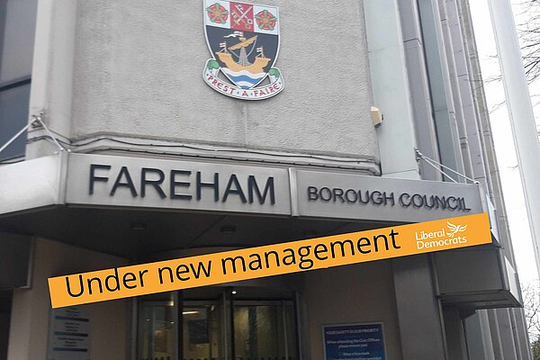 Fareham Civic Offices with pastiche Lib Dem orange banner saying "under new management"